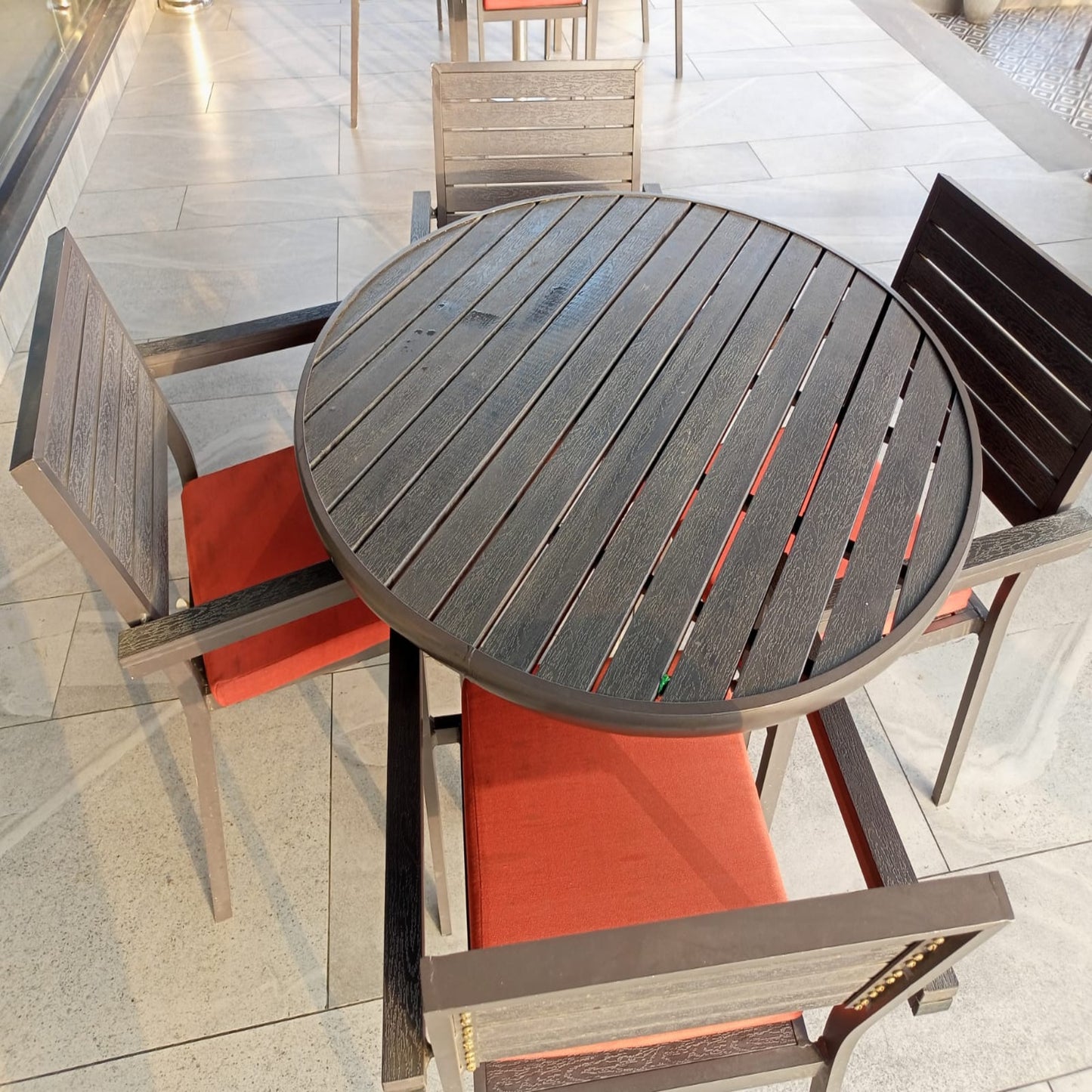 Kfc Pakistan restaurant round outdoor table with four chairs on a tiled patio