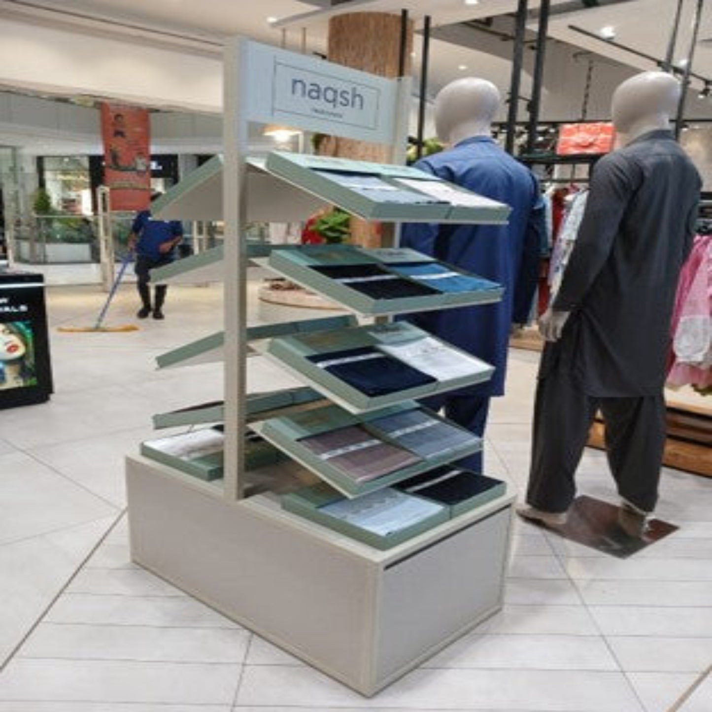 Display stand with colorful samples in a store setting, featuring the brand 'nagsh'.