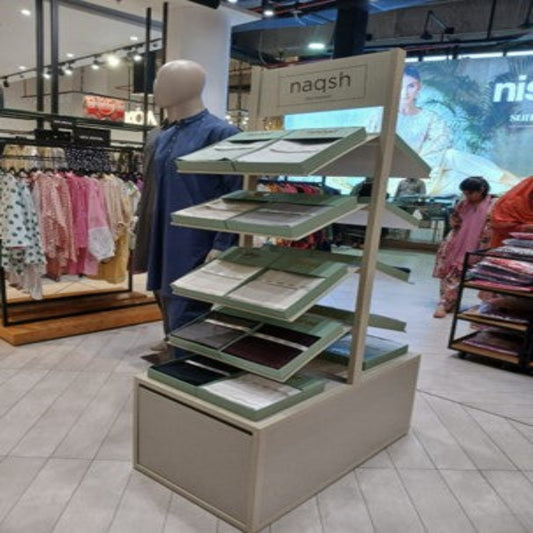 Display stand with products in a store setting, featuring the brand 'naqsh'.