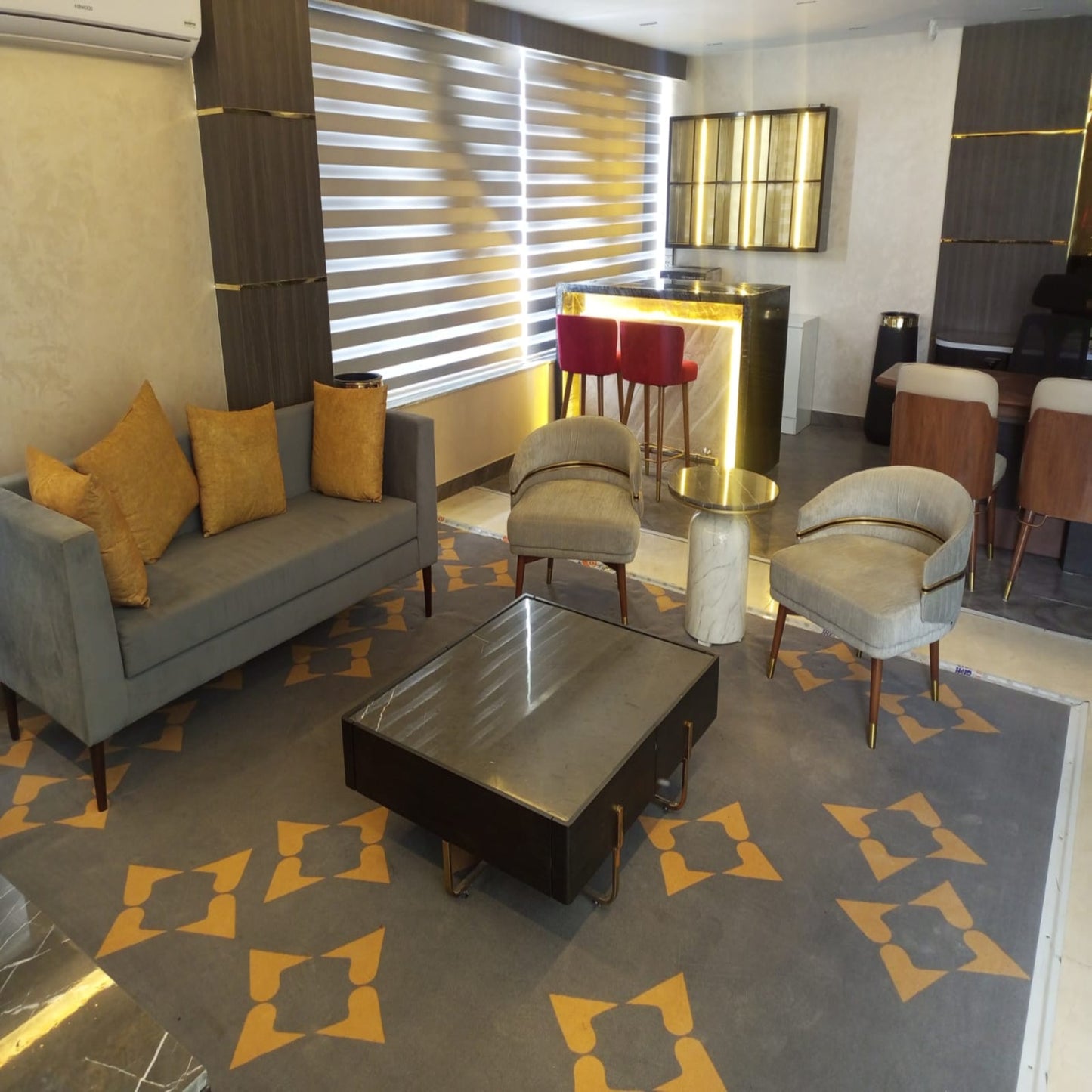 Modern living room with gray sofa, coffee table, and patterned rug.
