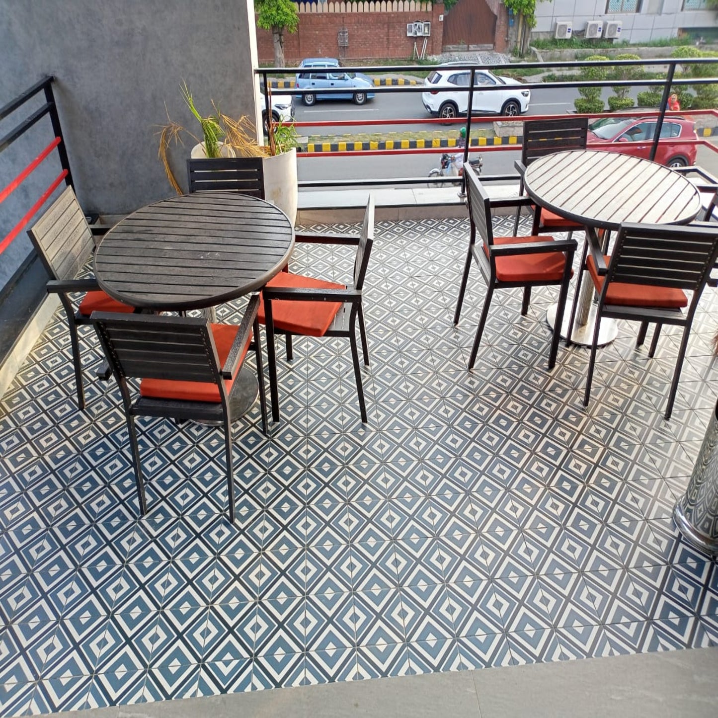 KFC fast food restaurant outdoor seating area with tables and chairs on a balcony with a patterned floor.