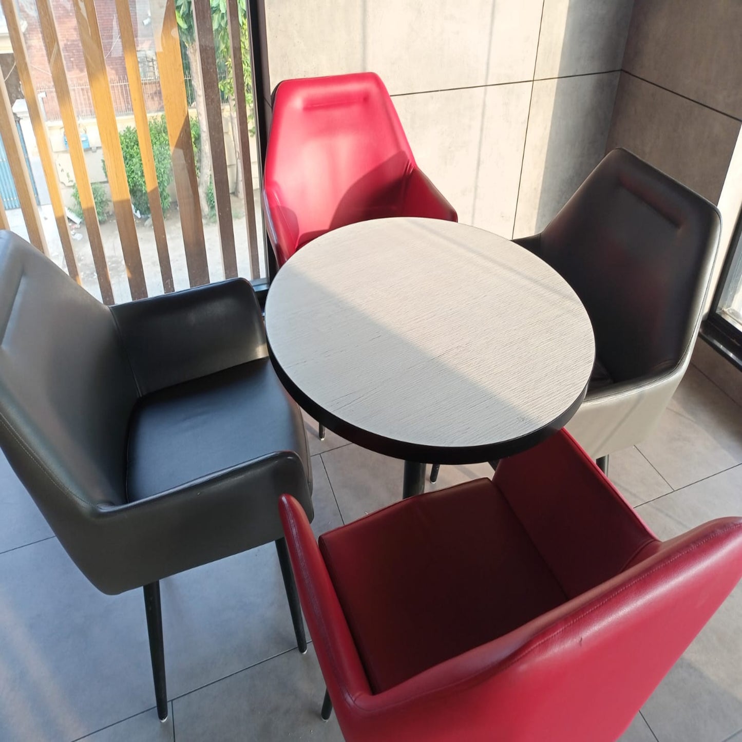 KFC Pakistan restaurant,round table with four chairs in various colors including black, red, and gray.