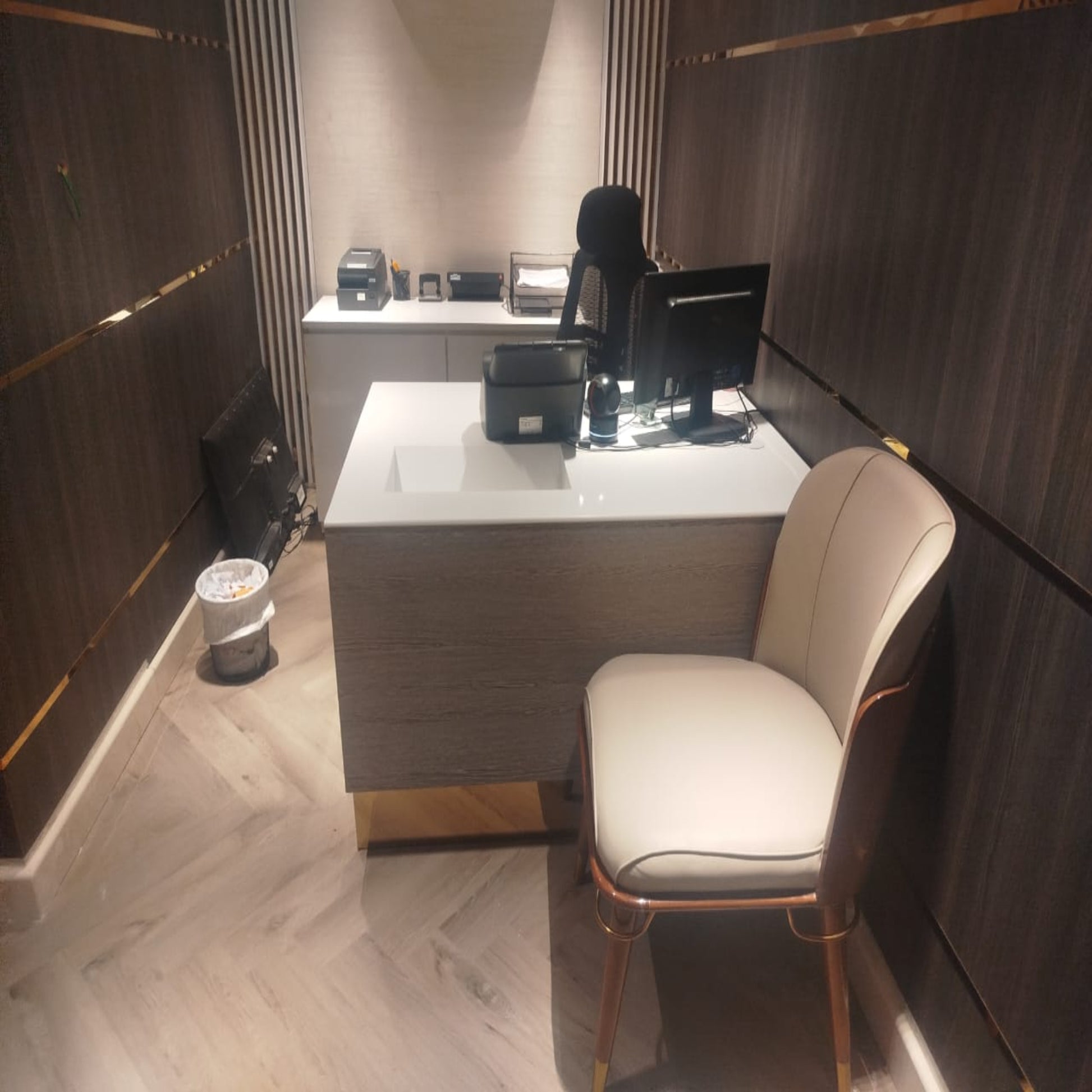 Modern office desk with chair in a room with wooden flooring and walls.