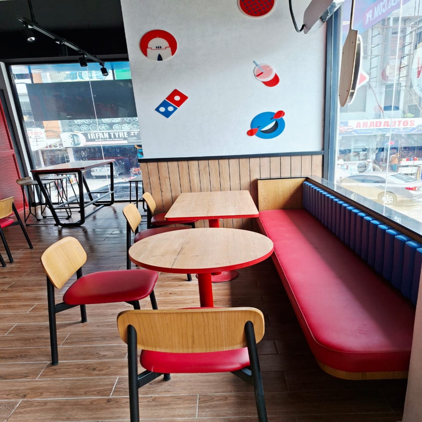 Restaurant interior with tables, chairs, and a wall with logos.