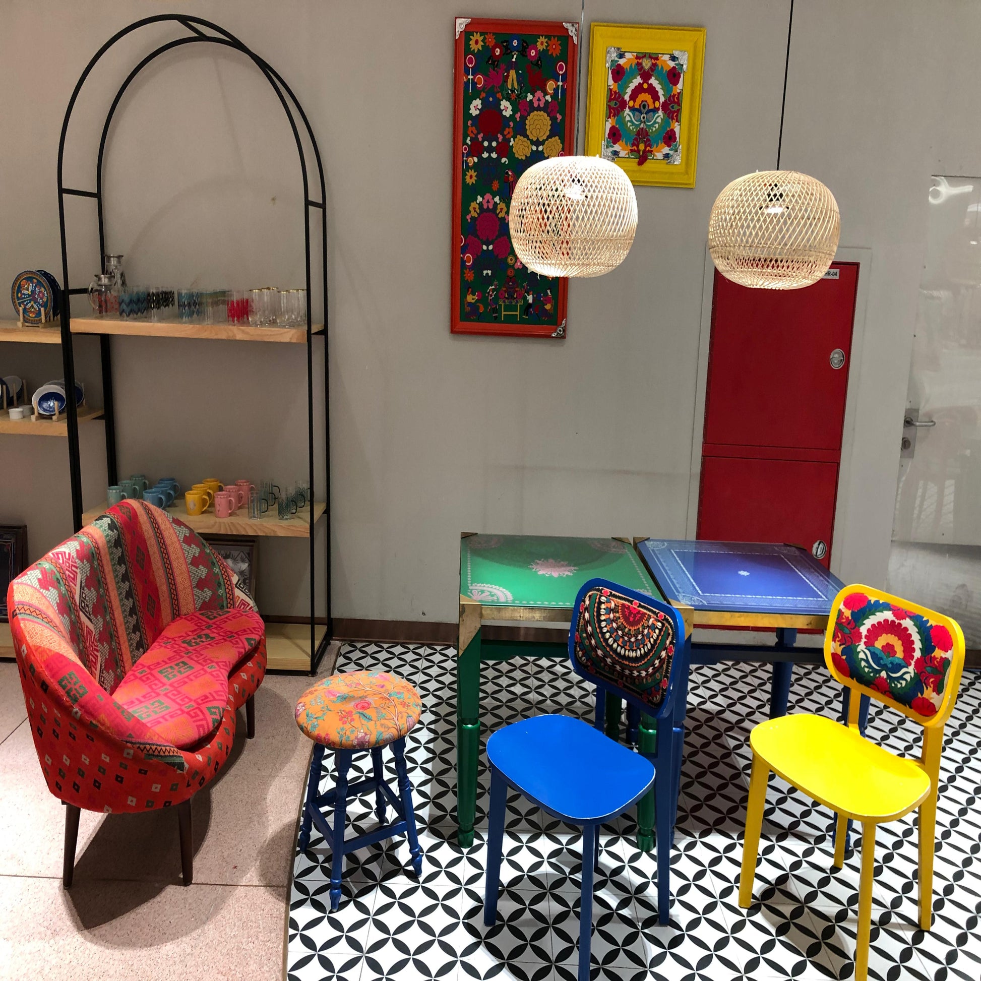 Colorful furniture and decor in a room with patterned floor and wall art.