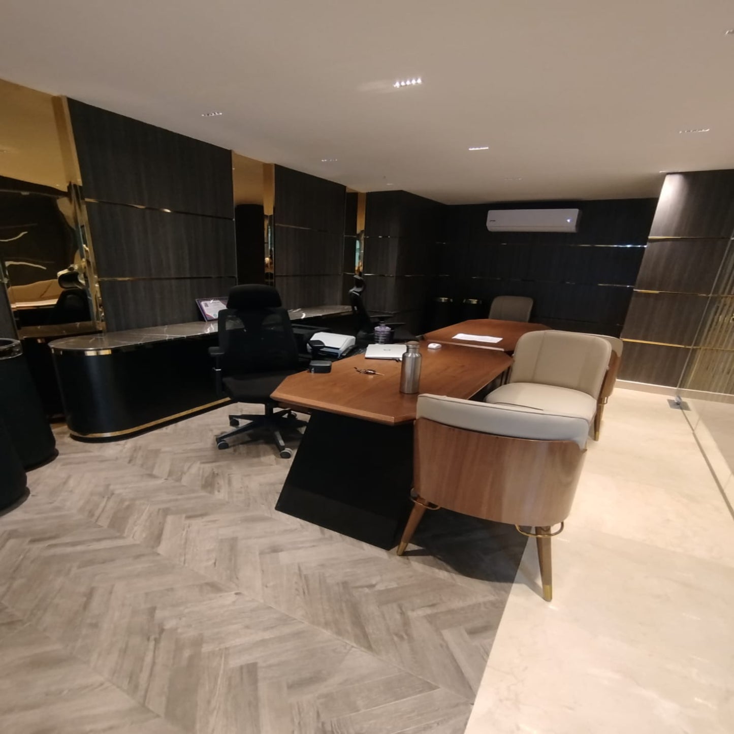 Modern office interior with a desk, chairs, and decorative elements.